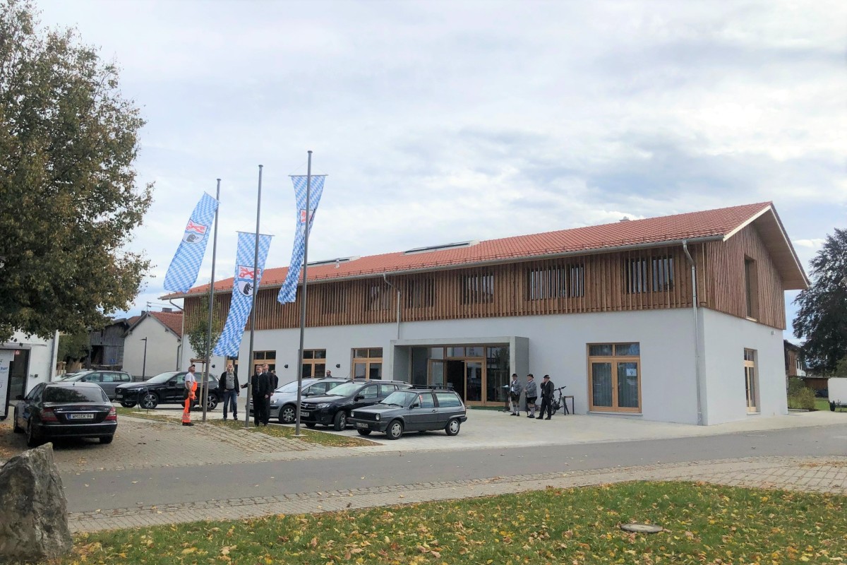 Ein Bild von einem Gebäude von außen mit Holzverkleidung im Obergeschoss.