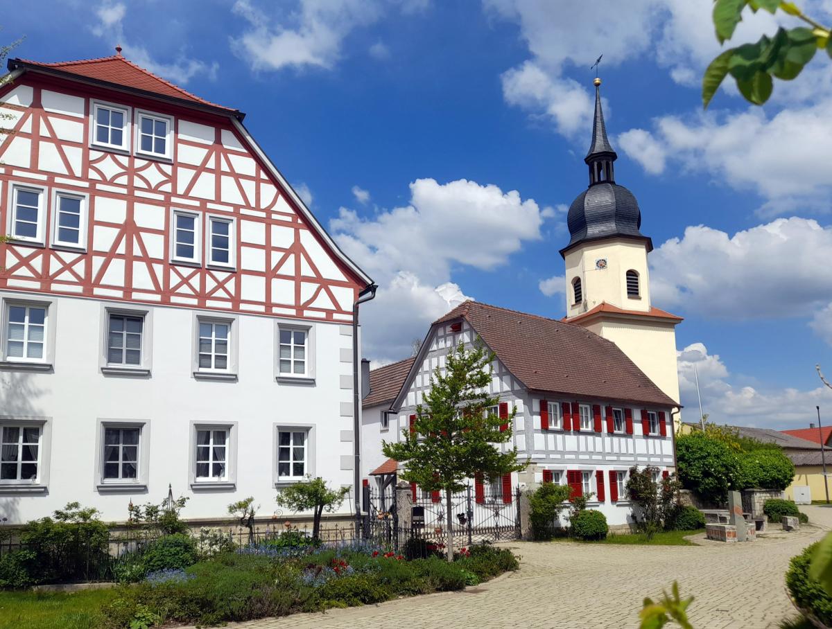 In Auernhofen stehen viele hübsche, sanierte Gebäude - ganz wichtig für die Menschen ist der Dorfplatz gleich bei der Kirche als Treffpunkt.