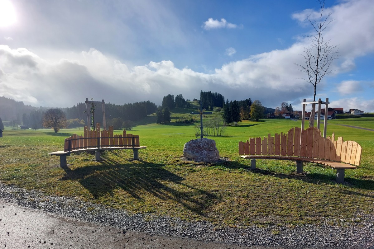 Zwei geschwungene Bänke und das Feldkreuz des neuen Aussichtspunkts.