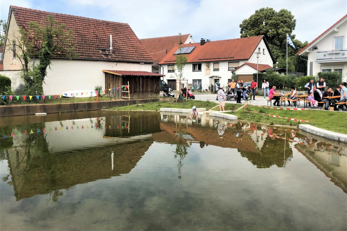 Bild vom Weiher mit Kindern und Menschen im Hintergrund.