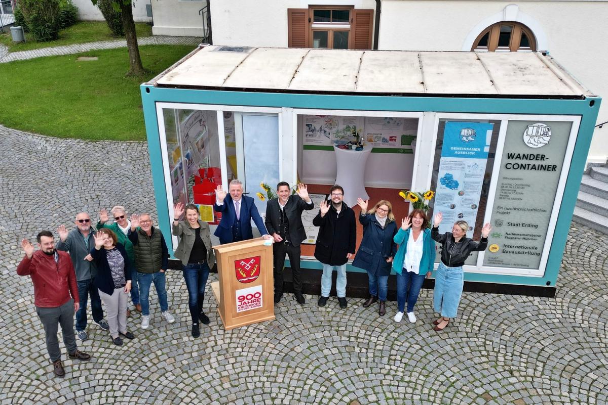 Akteure der IBA-Wanderausstellung zur Mobilität im Ampertal vor dem gläsernen Ausstellungscontainer.