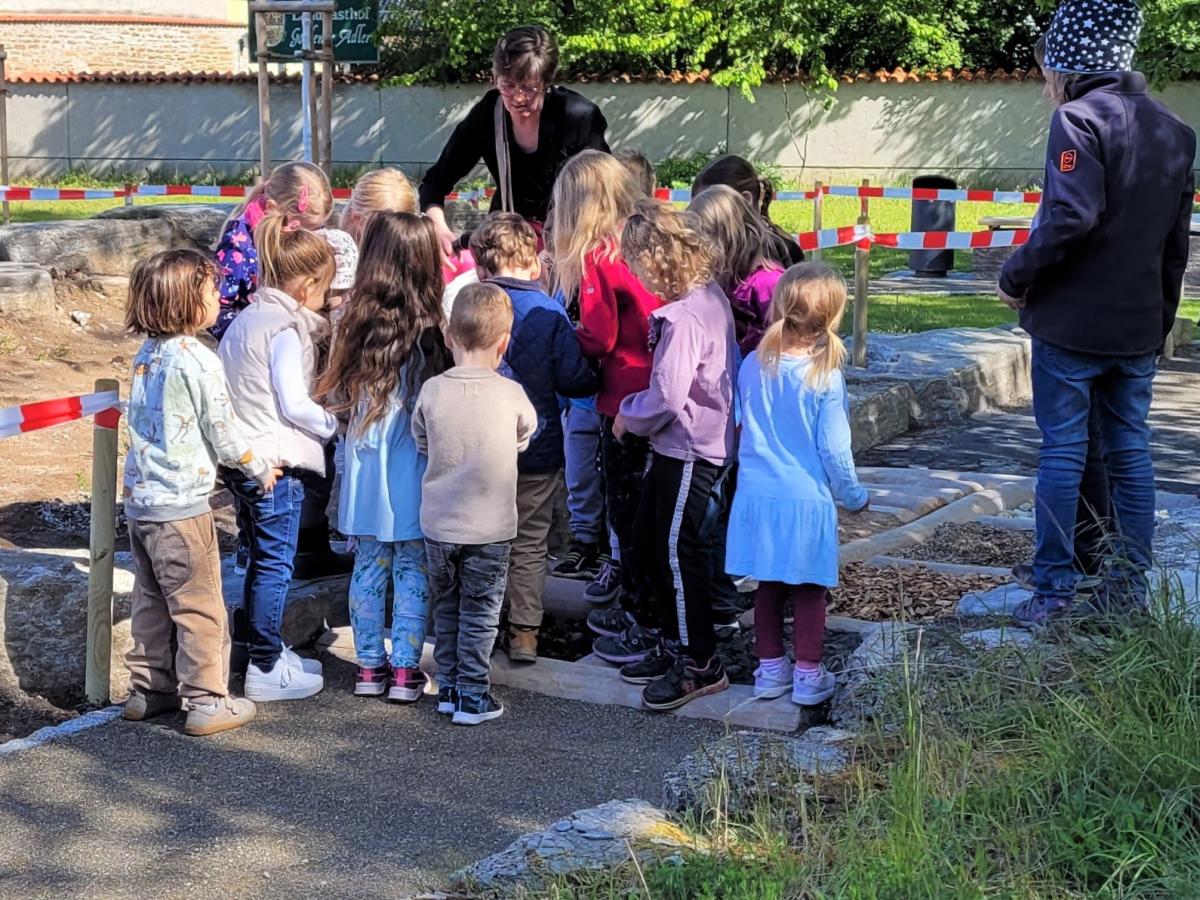 Eine Gruppe Mädchen und Jungen drängelt sich auf einem Weg mit wechselndem Bodenbelag.