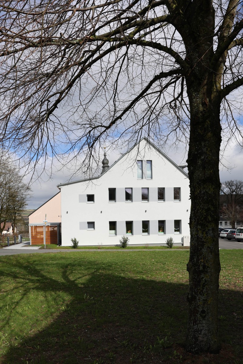 Ein Gebäude mit Baum im Vordergrund