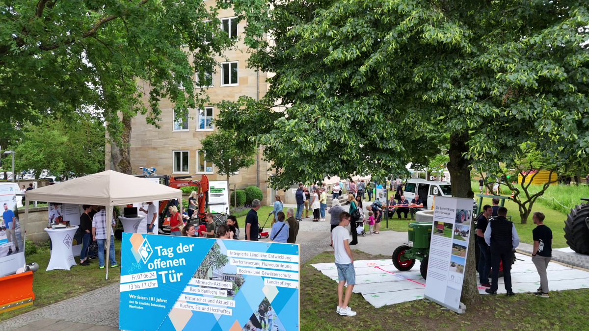 Ein Fest mit vielen Menschen und Ständen unter Bäumen