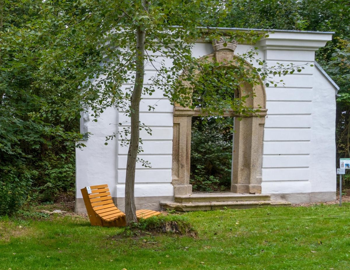 Eine Relaxliege läd zum Verweilen im Garten mit historischer Bausubstanz ein.