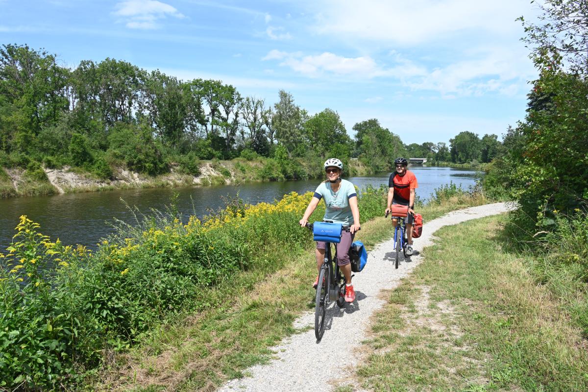 Zwei Radfahrer auf einer Rundtour am Wasser.